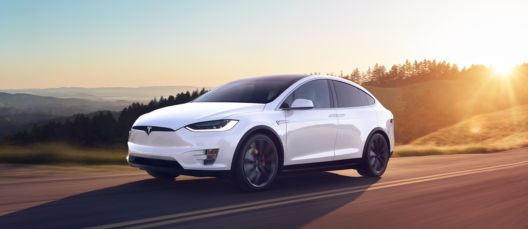 White Tesla Model X driving